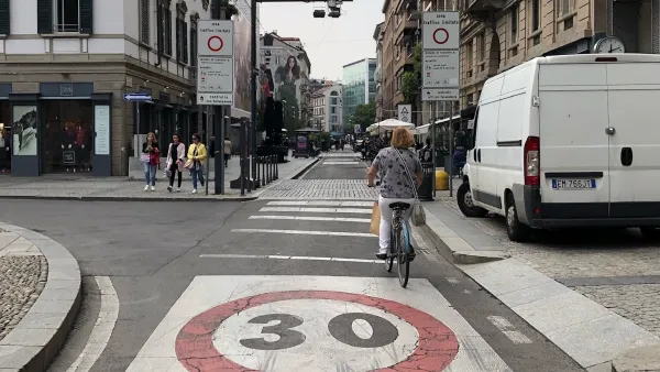 A bike rider navigates a bike lane in a traffic limited zone in Italy, where only one delivery van is visible on the street.