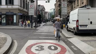 A bike rider navigates a bike lane in a traffic limited zone in Italy, where only one delivery van is visible on the street.