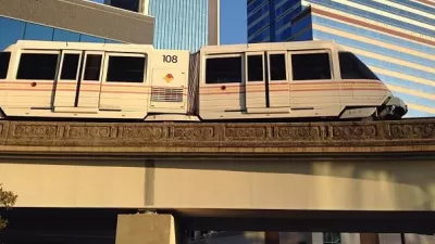 Jacksonville Skyway monorail train passing on elevated rail in front of downtown buildings