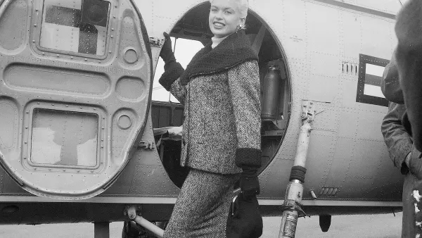 Actress Jayne Mansfield standing next to a military plane.