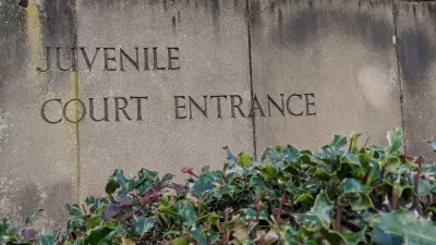 Weathered stone slabs with the words Juvenile Court Entrance engraved into it.