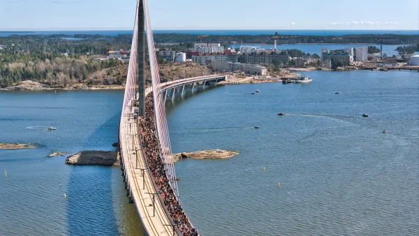 Aerial view of new pedestrian, bike and light rail bridge in Helsinki, Finland with crowd of people walking on the pedestrian path.