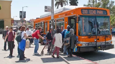 Bus passengers boarding an orange Los Angeles Metro bus on Sunset Boulevard.
