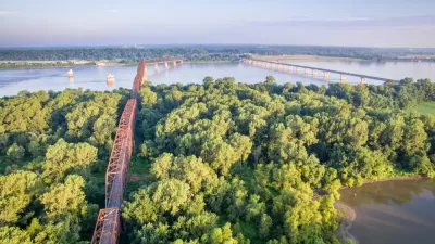 Two bridges cross the Mississippi Rivera midst thick vegetation and few other signs of human intervention.