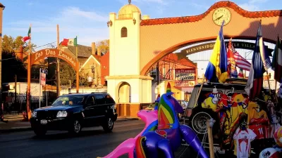 Spanish-style arch over street reading 'Bienvenidos a Little Village" in Chicago, Illinois at golden hour.