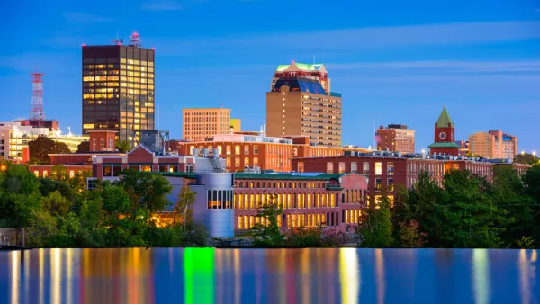The downtown of Mancheste, New Hampshire is nestled against the Merrimack River in the final light of day. 