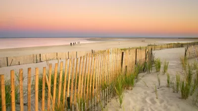 A fence shows a walkway to the beach in Cape Cod, Massachusetts.
