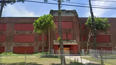 Google street view of vacant, boarded-up brick high school building in Memphis, Tennessee.