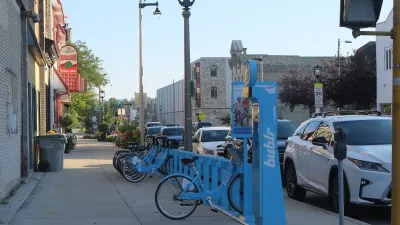 Blue Bublr bikes parked at station on sidewalk in Milwaukee, Wisconsin.