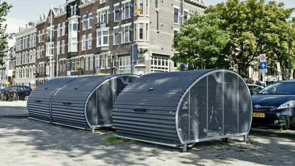 Rounded secure bike parking lockers on city street in Europe.
