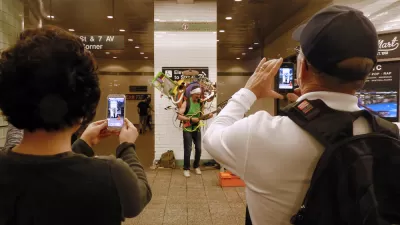 A performer holding numerous instruments plays for a crowd in the New York Subway.