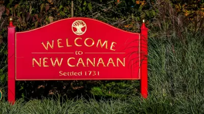 A red sign reads, “Welcome to New Canaan.”
