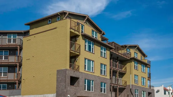 Four-story greenish-brown apartment buildings in Oakland, California.