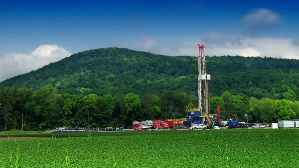 Marcellus shale gas-drilling site with tall white tower against green hills along PA Route 87, Lycoming County, Pennsylvania
