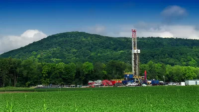 Marcellus shale gas-drilling site with tall white tower against green hills along PA Route 87, Lycoming County, Pennsylvania