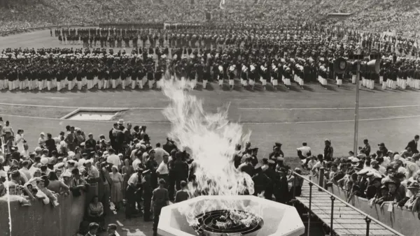 Black and white image of Olympic cauldron lit during opening ceremonies at 1948 London Olympics.