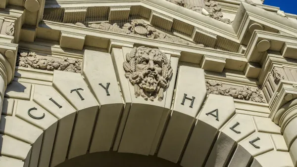 Close-up on :City Hall" carved into stone arch with gargoyle face in middle on Pasadena City hall entrance arch.