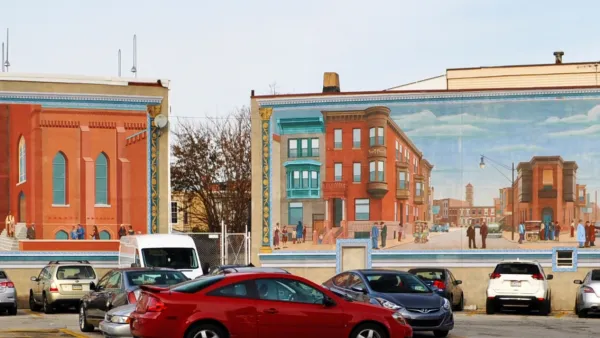 Parking lot in Philadelphia next to brick mid-rise buildings with murals of historic Phialdelphia.