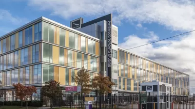 A movie studio buildiing located in Old Toronto's Port Lands is fenced off from the sidewalk and protected by a security guard station.