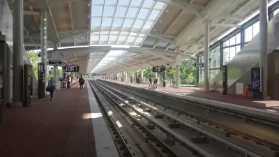 View of Potomac Yard train platform with some passengers waiting.
