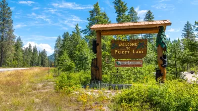 A wooden sign on the side of a road welcomes visitors to Priest Lake in Idaho.