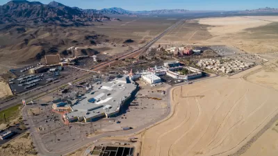 A aerical view of primm, Nevada, where I-15 bisects large casinos and parking lots on a sunny day.