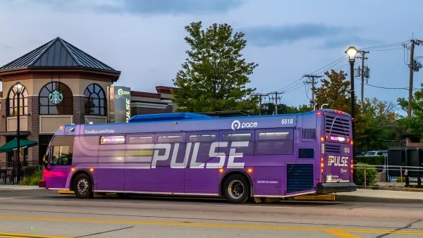 Purple bus with PULSE logo across it at dusk.