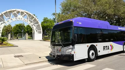 White and purple RTA bus inf ront of white archway to Armstrong transit station in New Orleans, Louisiana.