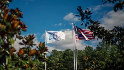 Flags on tall flagpoles with RTP logo and North Carolina flag at Research Triangle Park.