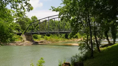 Old wooden bridge with steel railings at the War Eagle River in Rogers, Arkansas.