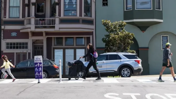 People walking on San Francisco street with 'Slow Streets' signs.