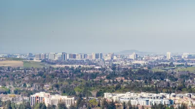 A view out over the city of San Jose, with downtown highrises in the background distance and smoggy air hanging overhead.