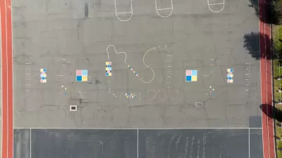 A school blacktop is viewed from bird’s eye view. The blacktop is adorned with painting and colors for games. but no children are present.
