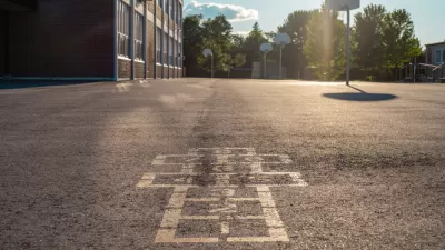 Hopscotch squares on concrete schoolyard with basketball hoop in background