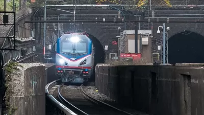 Amtrak train coming out of stone tunnel