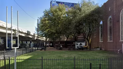 Google street view of grassy lot next to brick church with elevated freeway on other side in Houston, Texas.