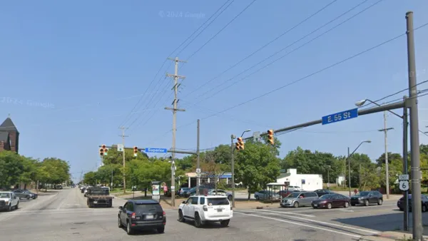 Google street view of wide street in Cleveland, Ohio with blue 55th Street sign and red brick three-story building visible in right corner.
