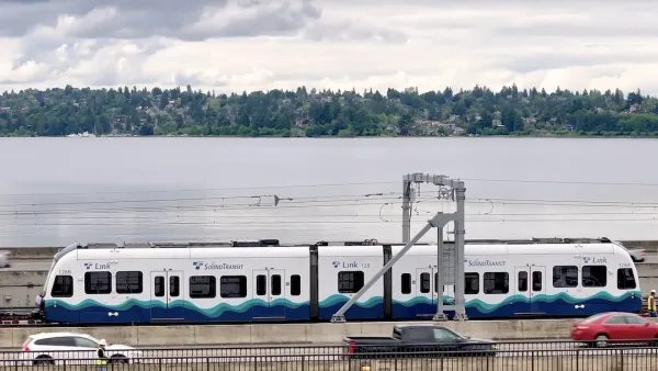 White and blue Sound Transit light rail train on floating brige.