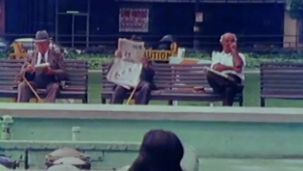 Screenshot of men sitting on bench outside in city in The Social Life of Small Urban Spaces.
