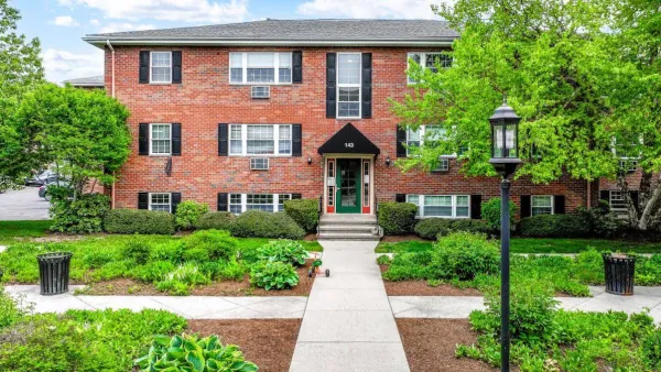 Red brick three-story garden apartment building in Newton, Massachusetts.