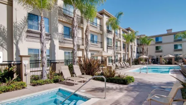 Hotel pool and hot tub at Spanish-style hotel in Carlsbad, California on sunny day.