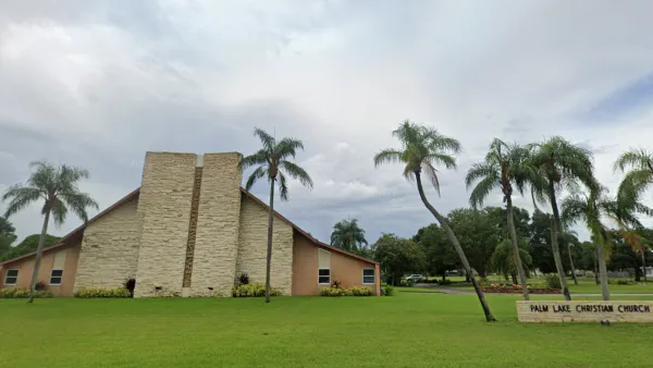 Google street view of modernist tan-colored triangular church building with tall skinny palm trees in front with green lawn in St. Petersburg, Florida.