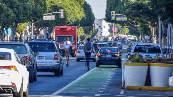 Car blocking bike lane in Santa Monica, CA with e-scooter rider behind it.