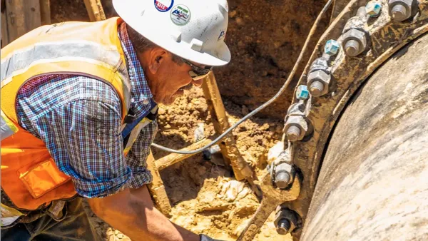A worker fixes a large pipe