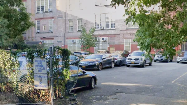 A parking lot between buildings in New York City with signs for NYPD vehicles only.