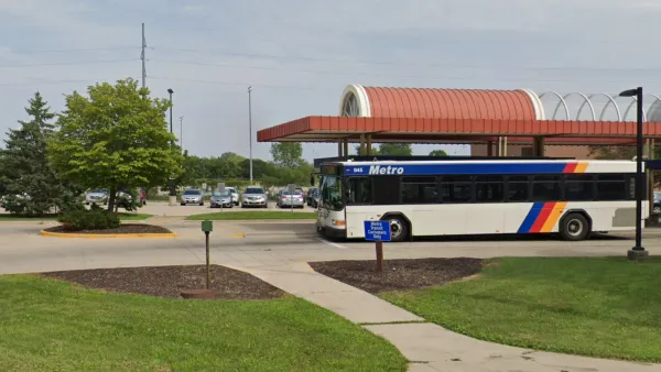 White bus with blue stripes at transit station in Madison, Wisconsin.