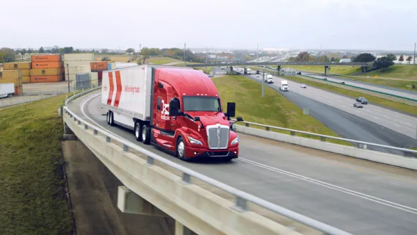 A red semi truck on a highway onramp