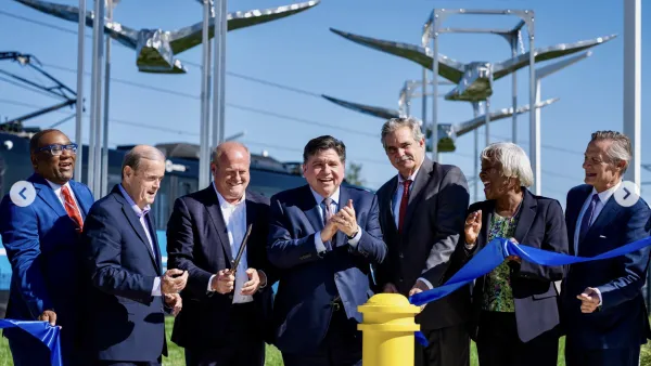 A group of politicians happily cut a blue ribbon.