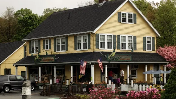 A yellow, two-story building named Ferns with two American flags.