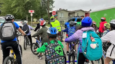 Group of children with backpacks and bike helmets going to school.